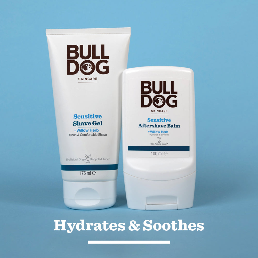 Two Bulldog Skincare products for sensitive skin on a blue background: Sensitive Shave Gel (175 ml) and Sensitive Aftershave Balm (100 ml). Text below reads: Hydrates & soothes with natural origin ingredients.