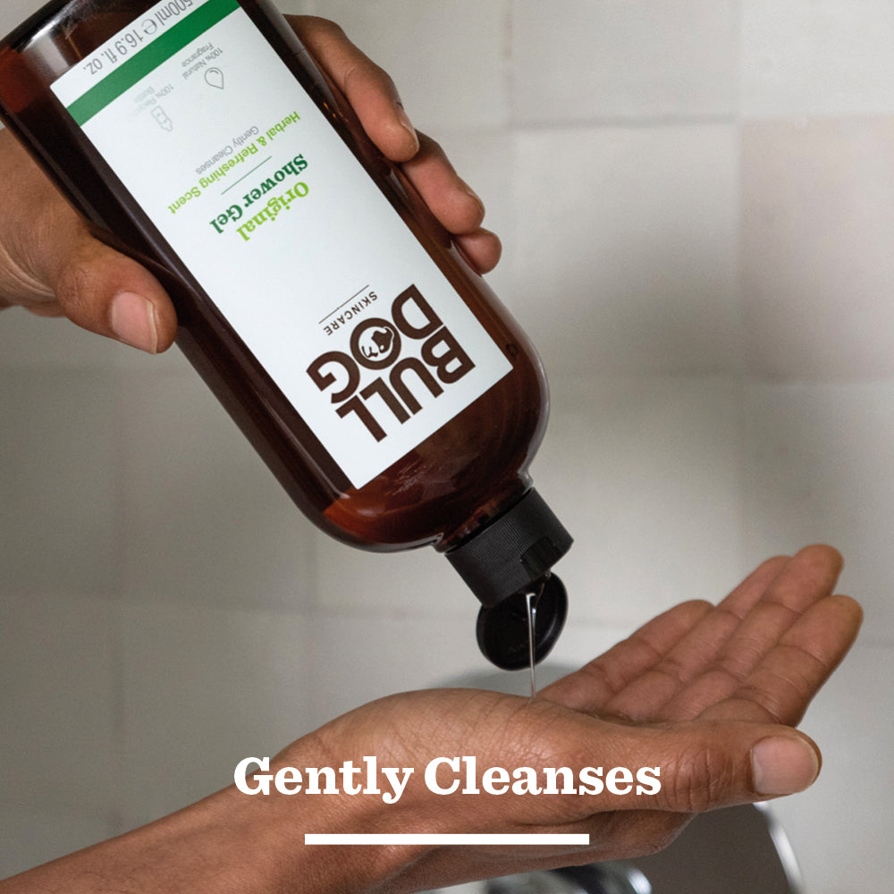 A person pours Bull Dog Original Shower Gel from a brown bottle onto their palm over a sink, with Gently Cleanses displayed—an ideal grooming bundle when paired with the Original Mega Bundle.