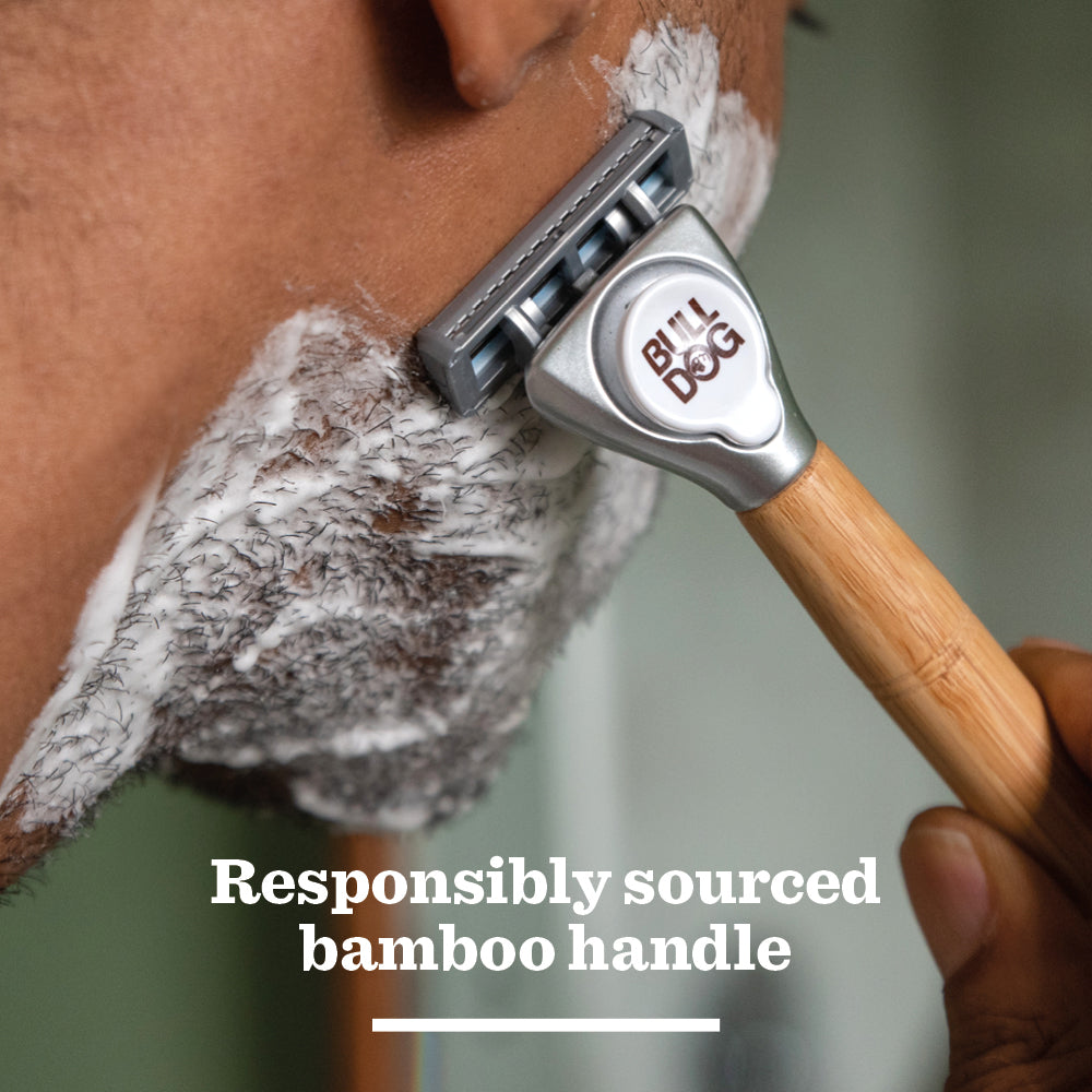 A person shaves with the Sensitive Bamboo Razor, its brand visible. Shaving cream covers part of their face. Text below: Responsibly sourced bamboo handle and sensitive steel blades for a smooth shave.