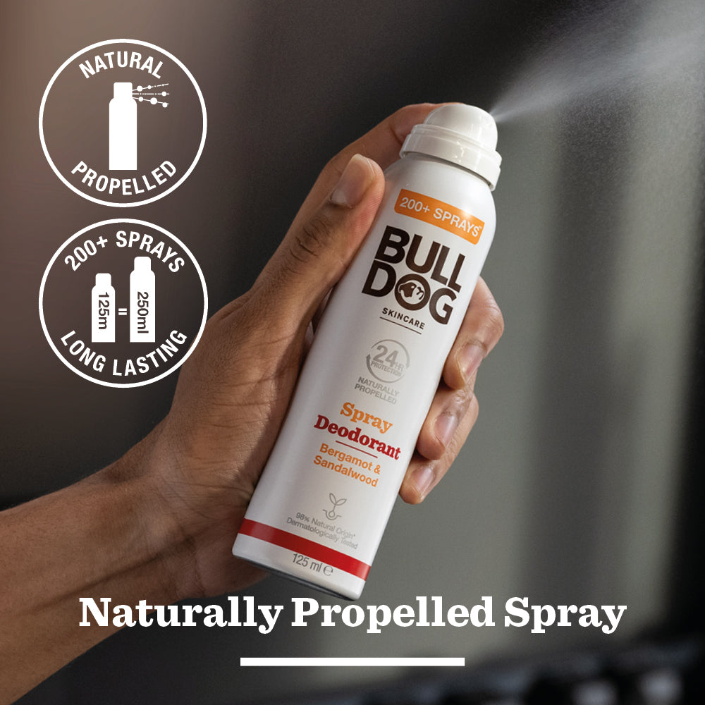 A hand sprays the Energising Spray Deodorant Bundle can; text highlights Naturally Propelled Spray, 200+ sprays, 125ml, and Bergamot & Sandalwood scent with Natural Propelled and Long Lasting icons.