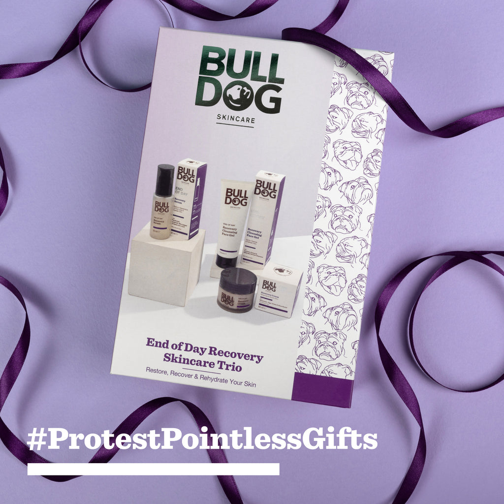 The End of Day Recovery Trio gift set sits on a purple background with a ribbon and floral pattern. Text below reads #ProtestPointlessGifts.