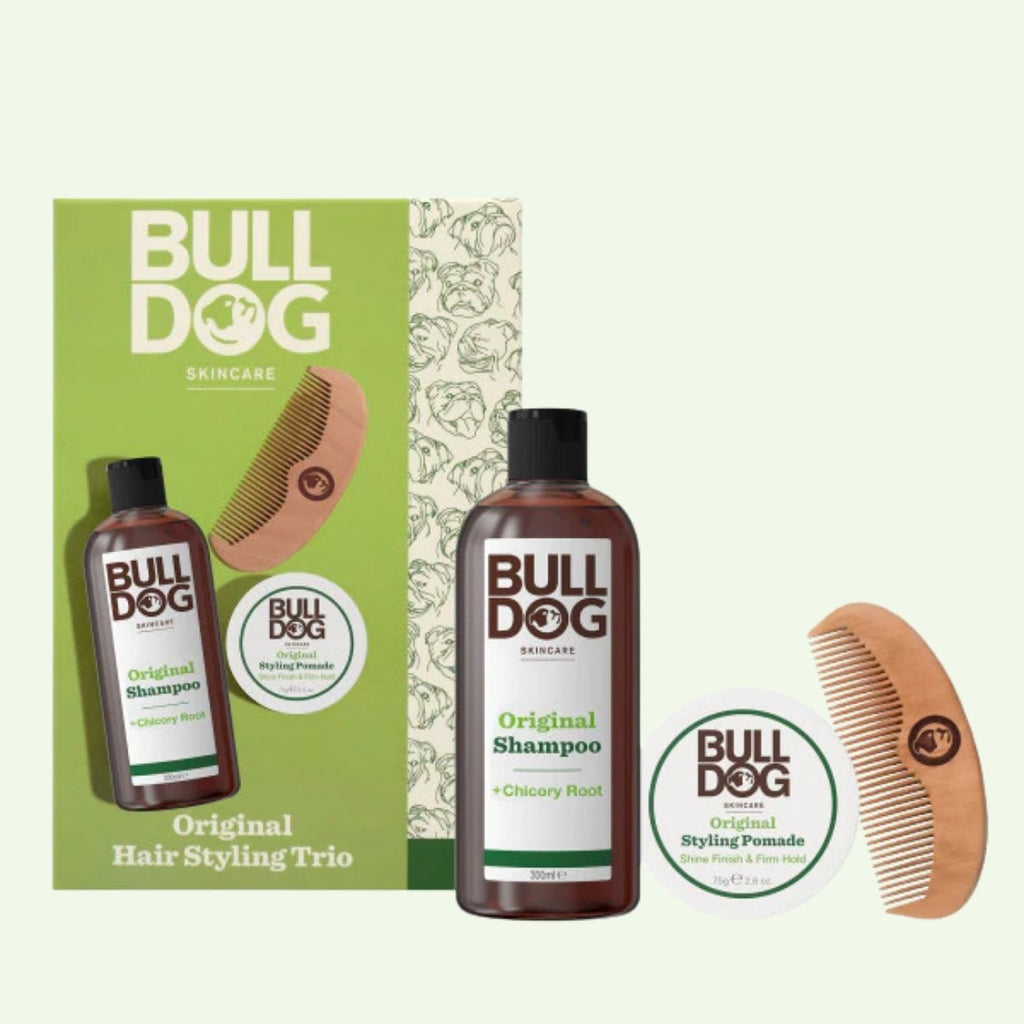 The Hair Styling Trio includes a brown shampoo bottle, a white pomade tub, and a wooden comb in a stylish box—making it the perfect men’s gift set, beautifully arranged on a light background.